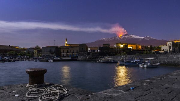 Snow-covered Mount Etna, Europe's most active volcano, spews lava during an eruption as the Sicilian village of Pozzillo, Italy, is visible in foreground, in the early hours of Tuesday, April 11, 2017 - Sputnik International