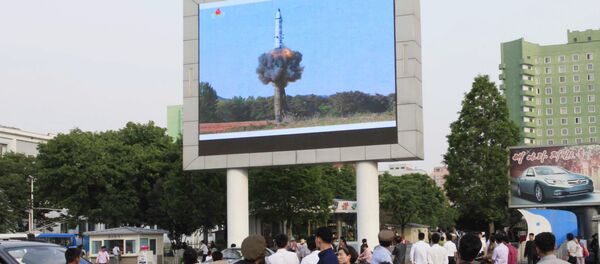 People watch a news broadcast on the launch of the solid-fuel Pukguksong-2 missile on a screen in front of the railway station in Pyongyang, North Korea, Monday, May 22, 2017. - Sputnik International