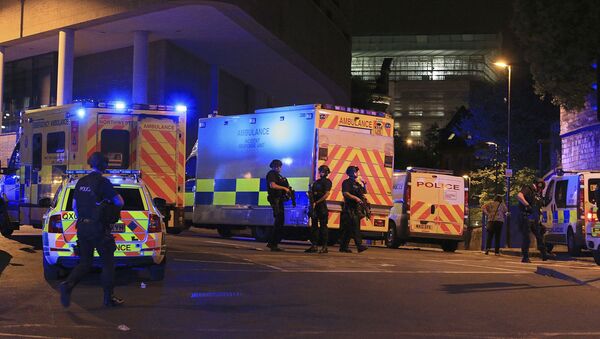 Armed police positioned near emergency vehicles after reports of an explosion at the Manchester Arena during an Ariana Grande concert in Manchester, England Monday, May 22, 2017. - Sputnik International