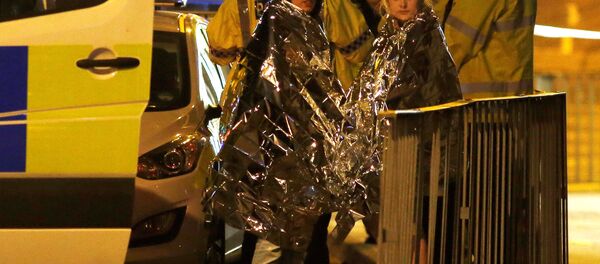 Two women wrapped in thermal blankets stand near the Manchester Arena, where U.S. singer Ariana Grande had been performing, in Manchester, northern England, Britain, May 23, 2017. Two women wrapped in thermal blankets stand near the Manchester Arena, where U.S. singer Ariana Grande had been performing, in Manchester, northern England, Britain, May 23, 2017. - Sputnik International