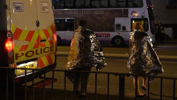 Concert goers wait to be picked up at the scene of a suspected terrorist attack during a pop concert by US star Ariana Grande in Manchester, northwest England on May 23, 2017. - Sputnik International