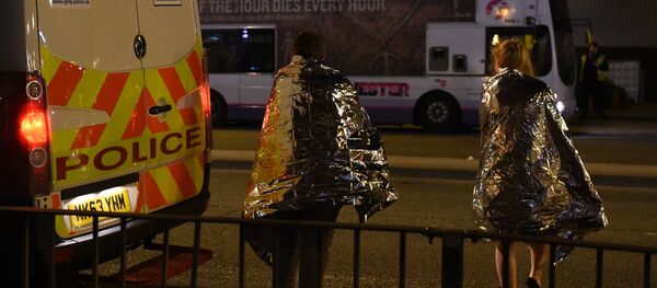 Concert goers wait to be picked up at the scene of a suspected terrorist attack during a pop concert by US star Ariana Grande in Manchester, northwest England on May 23, 2017. - Sputnik International