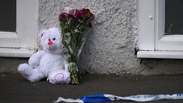 A floral tribute and a teddy bear are pictured alongside police tape near to the Manchester Arena, in Manchester, northwest England on May 23, 2017 - Sputnik International