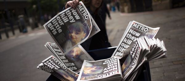 A woman picks a newspaper reporting the news on the suicide attack at a concert by Ariana Grande that killed more than 20 people as it ended Monday night in central Manchester, Britain, Wednesday, May 24, 2017. - Sputnik International