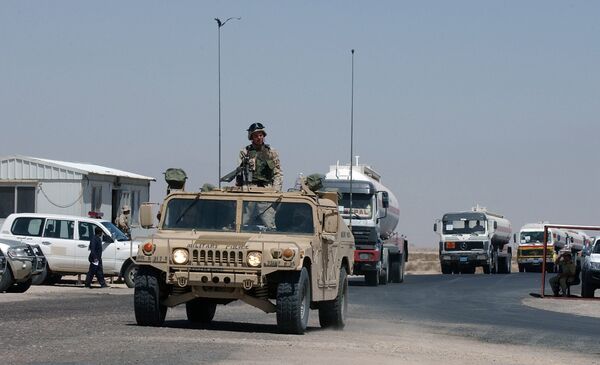 A convoy of fuel tanker trucks escorted by a US Army vehicle enter Kuwait at the military border post of Abdaly in the Kuwait-Iraq frontier in this file photo taken January 2006 A convoy of fuel tanker trucks escorted by a US Army vehicle enter Kuwait at the military border post of Abdaly in the Kuwait-Iraq frontier in this file photo taken January 2006 - Sputnik International