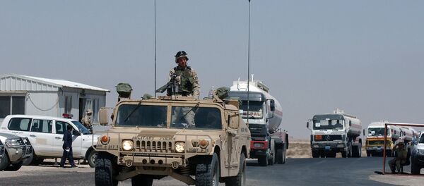 A convoy of fuel tanker trucks escorted by a US Army vehicle enter Kuwait at the military border post of Abdaly in the Kuwait-Iraq frontier in this file photo taken January 2006 A convoy of fuel tanker trucks escorted by a US Army vehicle enter Kuwait at the military border post of Abdaly in the Kuwait-Iraq frontier in this file photo taken January 2006 - Sputnik International