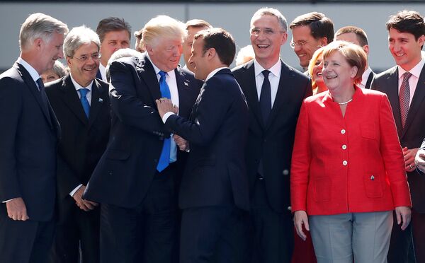 From L-R, Belgium's King Philipe, Italian Prime Minister Paolo Gentiloni, U.S. President Donald Trump who shakes hands with French President Emmanuel Macron, NATO Secretary General Jens Stoltenberg, Dutch Prime Minster Mark Rutte, German Chancellor Angela Merkel, and Canada's Prime Minister Justin Trudeau gather with NATO member leaders to pose for a family picture before the start of their summit in Brussels, Belgium, May 25, 2017 - Sputnik International