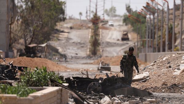 A Syrian Democratic Forces (SDF) fighter walks through a damaged street in the Syrian city of Tabqa, after SDF captured it from Daesh militants, May 12, 2017 - Sputnik International