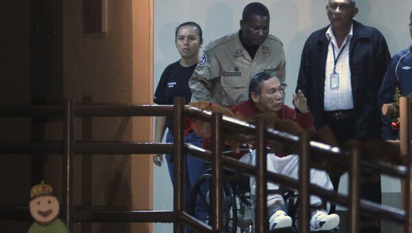 Panama's ex-dictator Manuel Noriega gestures while being carried in a wheelchair by a police officer inside El Renacer prison in the outskirts of Panama City, Sunday, Dec. 11, 2011 - Sputnik International