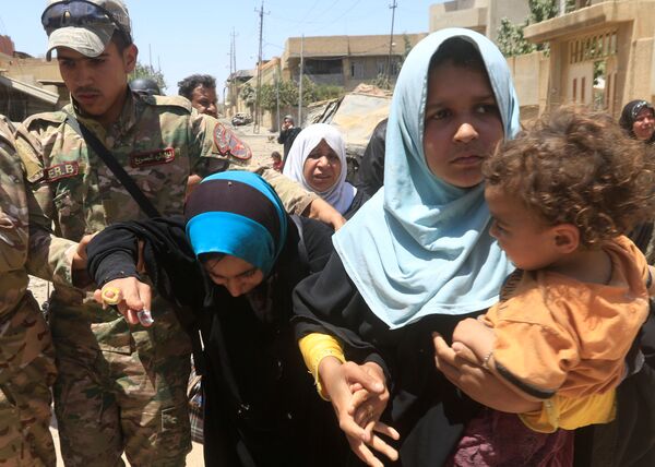 Iraqi rapid response forces help displaced Iraqi women who fled homes during a fight between Iraqi forces and Islamic State militants in al-Zanjili neighbourhood, north of Old City district of Mosul, Iraq May 30, 2017. Iraqi rapid response forces help displaced Iraqi women who fled homes during a fight between Iraqi forces and Islamic State militants in al-Zanjili neighbourhood, north of Old City district of Mosul, Iraq May 30, 2017. - Sputnik International