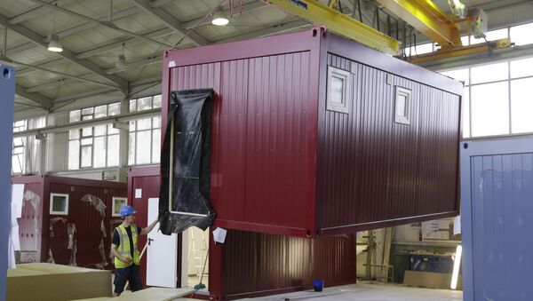 Worker moves a modular container - Sputnik International