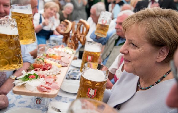 German Chancellor Angela Merkel holds a glass of beer as she attends an election campaign event of the Christian Social Union (CSU), Bavarian sister party of her conservative Christian Democratic Union (CDU), in a beer tent at the Truderinger Festwoche fair in Munich, southern Germany, on May 28, 2017. German Chancellor Angela Merkel holds a glass of beer as she attends an election campaign event of the Christian Social Union (CSU), Bavarian sister party of her conservative Christian Democratic Union (CDU), in a beer tent at the Truderinger Festwoche fair in Munich, southern Germany, on May 28, 2017. - Sputnik International