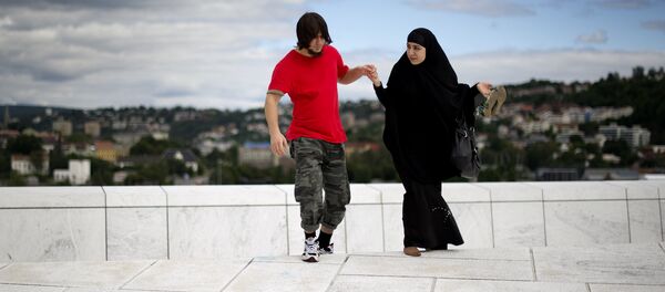 A man helps a woman up a step on the roof of the Opera house in Oslo - Sputnik International
