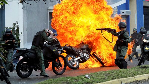 Полицейский отряд во время столкновений с протестующими против политики Николаса Мадуро - Sputnik International
