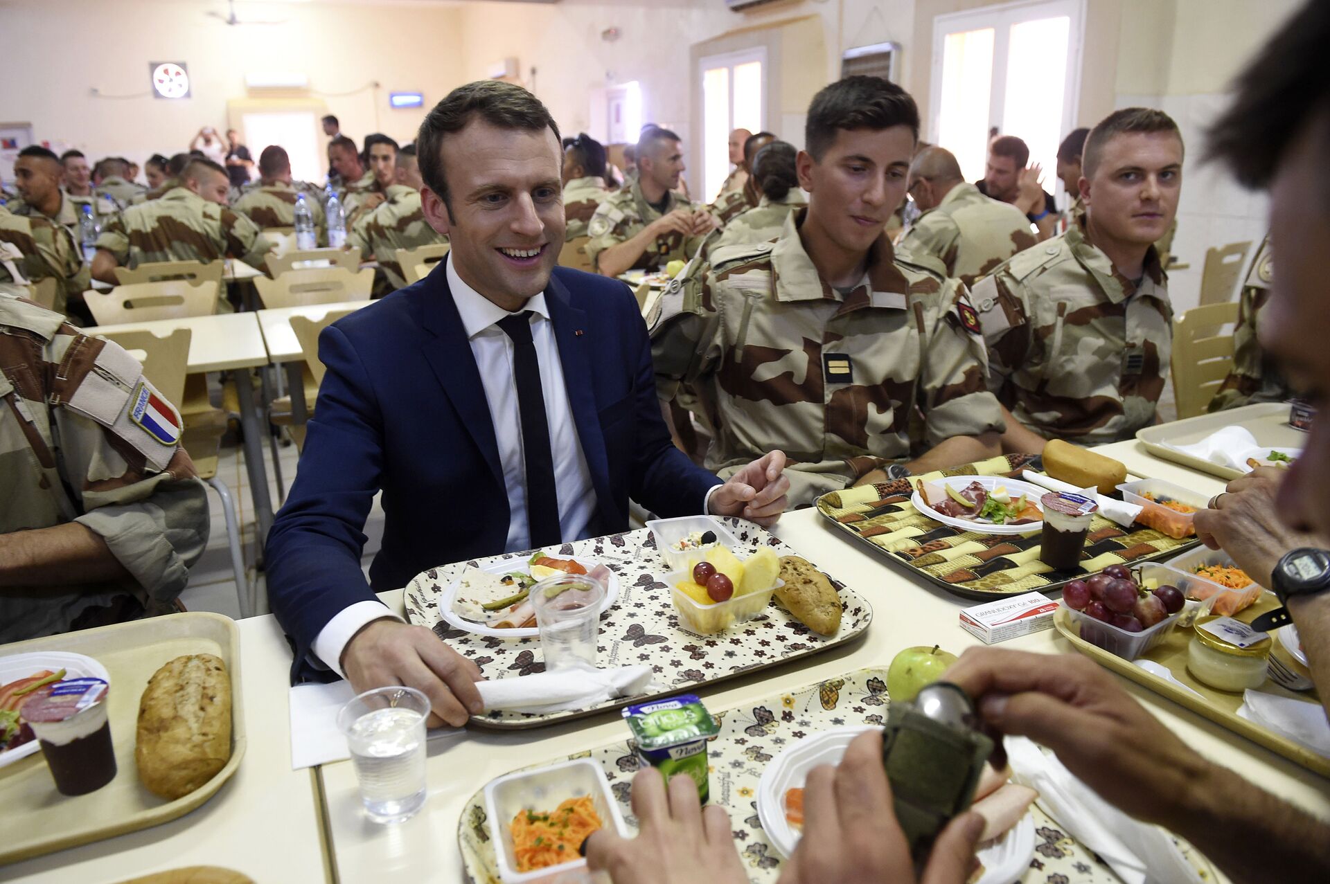 French President Emmanuel Macron (C) has a lunch break with French troops during his visit to France's Barkhane counter-terrorism operation in Africa's Sahel region in Gao, northern Mali, on May 19, 2017.  - Sputnik International, 1920, 09.11.2022