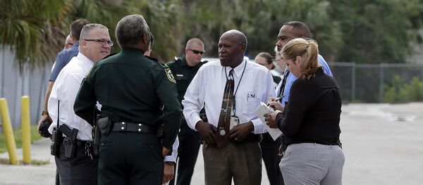 Authorities confer near the scene of a shooting where they said there were multiple fatalities in an industrial area near Orlando, Fla., Monday, June 5, 2017 - Sputnik International