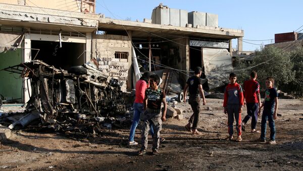 People walk at a site hit by an airstrike in the rebel-held Tafas town, in Deraa Governorate, Syria June 5, 2017 - Sputnik International