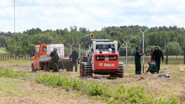 Workers install poles for the fence near the Sudargas border crossing point with Russia in Ramoniskiai, Lithuania June 5, 2017 - Sputnik International