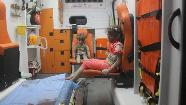 5-year-old Omran Daqneesh and his sister sit in an ambulance after being pulled out of a building hit by an airstrike in Aleppo, Syria, on Aug. 17, 2016 - Sputnik International
