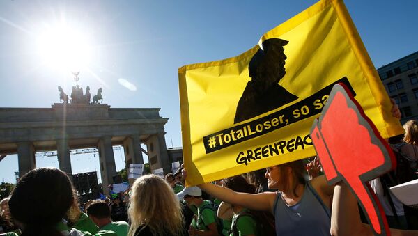 People hold banners as they protest next to the Brandenburg Gate, beside the U.S. embassy, against the U.S. withdrawal from the Paris climate change deal, in Berlin, Germany, June 2, 2017 - Sputnik International