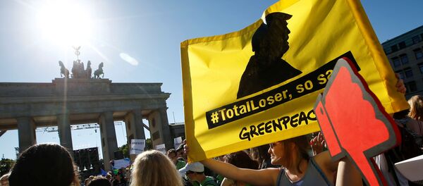 People hold banners as they protest next to the Brandenburg Gate, beside the U.S. embassy, against the U.S. withdrawal from the Paris climate change deal, in Berlin, Germany, June 2, 2017 - Sputnik International