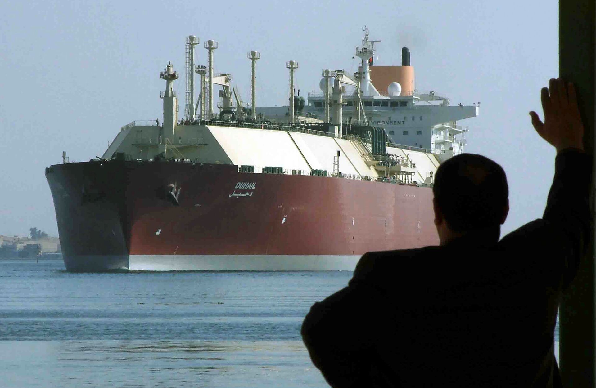 A man looks as the world's biggest Liquefied Natural Gas (LNG) tanker, Qatari-flagged DUHAIL as she crosses through the Suez Canal (File) - Sputnik International, 1920, 08.10.2021