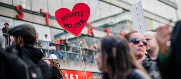 People hold signs reading 'refugees welcome' as they take part in demonstration in solidarity with migrants seeking asylum in Europe after fleeing their home countries in Stockholm (File) People hold signs reading 'refugees welcome' as they take part in demonstration in solidarity with migrants seeking asylum in Europe after fleeing their home countries in Stockholm (File) - Sputnik International
