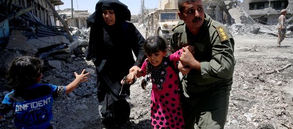 Iraqi soldiers help residents displaced by fighting between Iraqi forces and Islamic State militants in Mosul's al-Zanjili's district, Iraq June 7, 2017. Iraqi soldiers help residents displaced by fighting between Iraqi forces and Islamic State militants in Mosul's al-Zanjili's district, Iraq June 7, 2017. - Sputnik International