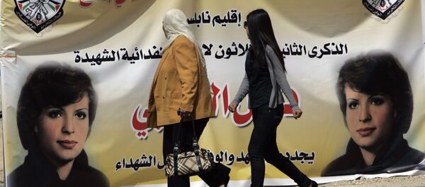 Palestinian women walk past a banner in the West bank town of Bireh, which pictures Fatah member Dalal Mughrabi, who led an attack on an Israeli bus near Tel Aviv, killing 36 people in 1978 Palestinian women walk past a banner in the West bank town of Bireh, which pictures Fatah member Dalal Mughrabi, who led an attack on an Israeli bus near Tel Aviv, killing 36 people in 1978 - Sputnik International