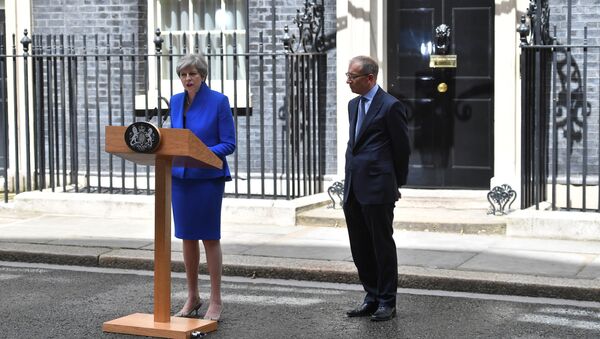 Britain's Prime Minister and leader of the Conservative Party Theresa May, (L), accompanied by her husband Philip, delivers a statement outside 10 Downing Street in central London on June 9, 2017 as results from a snap general election show the Conservatives have lost their majority. - Sputnik International