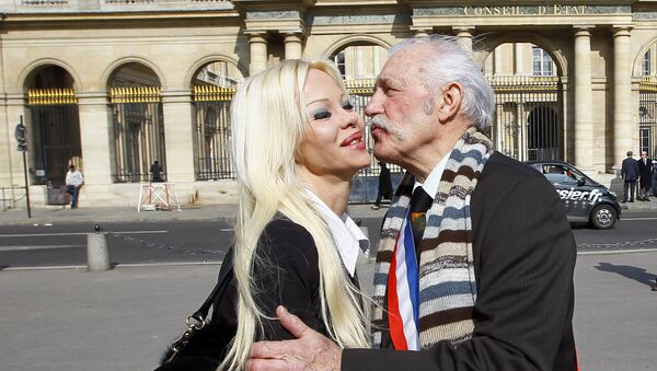 Isabelle Laeng, known as Cindy Lee, left, of the Pleasure Party campaigning for France's upcoming presidential election, kisses Roger Lagache, right, French Major of a northern village of Tollent, in front of the France's Conseil d'Etat in Paris, France. (File) - Sputnik International