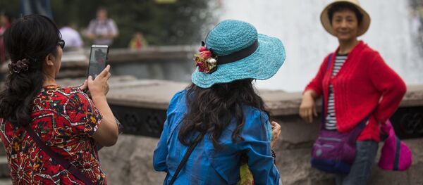 Chinese tourists make photos at a fountain just off Red Square in Moscow, Russia Chinese tourists make photos at a fountain just off Red Square in Moscow, Russia - Sputnik International