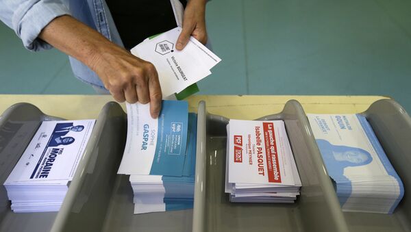 Voter picks up ballots at a polling station before voting for the first round of parliamentary elections in Marseille, southern France, Sunday, June 11, 2017 - Sputnik International