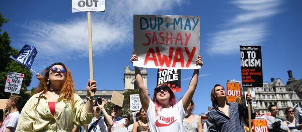 Anti-Conservative Party and anti-Democratic Unionist Party (DUP) demonstrators gather with placards in Parliament Square in front of the Houses of Parliament in central London on June 10, 2017 Anti-Conservative Party and anti-Democratic Unionist Party (DUP) demonstrators gather with placards in Parliament Square in front of the Houses of Parliament in central London on June 10, 2017 - Sputnik International