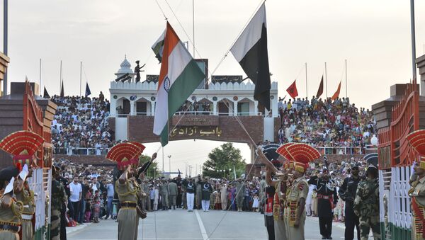 In this July 21, 2015 file photo, Indian and Pakistani flags are lowered during a daily retreat ceremony at the India-Pakistan joint border check post of Attari-Wagah near Amritsar, India - Sputnik International