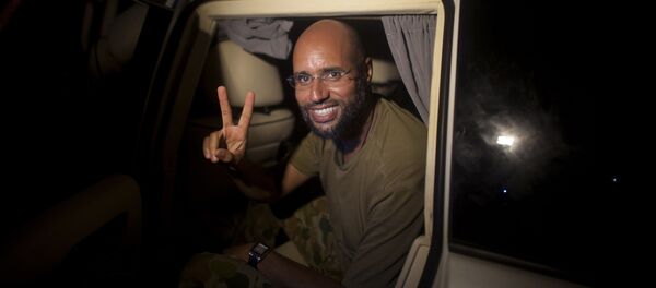 Moammar Gadhafi's son Seif al-Islam makes the victory sign as he appears at the Rixos hotel in Tripoli, Libya (File) Moammar Gadhafi's son Seif al-Islam makes the victory sign as he appears at the Rixos hotel in Tripoli, Libya (File) - Sputnik International
