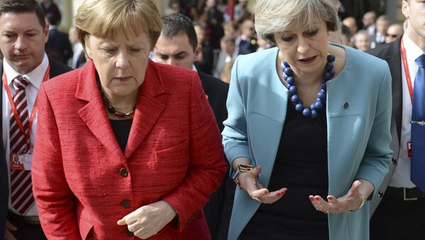 German Chancellor Angela Merkel, left, speaks with British Prime Minister Theresa May as they walk with other EU leaders during an event at an EU summit in Valletta, Malta, on Friday, Feb. 3, 2017. - Sputnik International