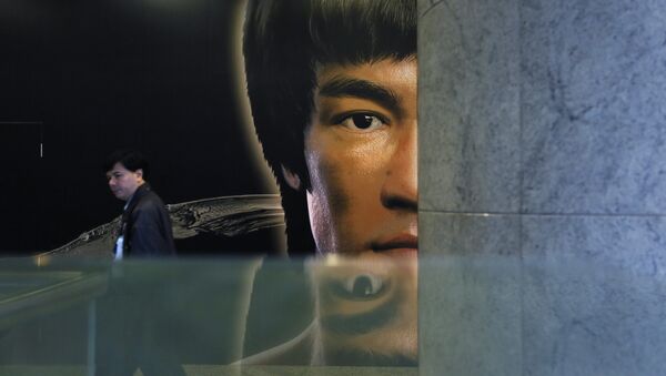 A man walks past a promotional poster of Bruce Lee's memorial exhibition at the Hong Kong Heritage Museum in Hong Kong, Monday, March 31, 2014, to mark the 40th anniversary of the death of Lee - Sputnik International