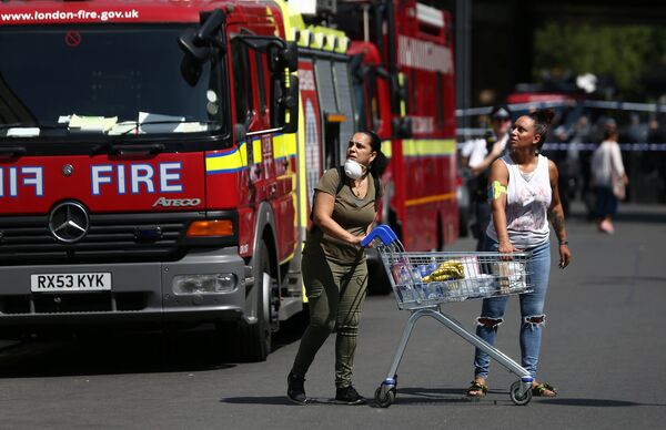 People react near a tower block severely damaged by a serious fire, in north Kensington, West London, Britain June 14, 2017. People react near a tower block severely damaged by a serious fire, in north Kensington, West London, Britain June 14, 2017. - Sputnik International
