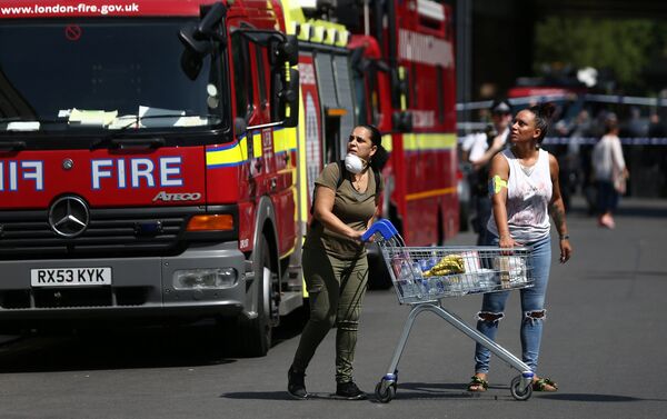 People react near a tower block severely damaged by a serious fire, in north Kensington, West London, Britain June 14, 2017. - Sputnik International