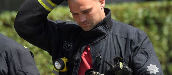 Firefighters rest near a tower block, severely damaged in a serious fire, in north Kensington, West London, Britain June 14, 2017. Firefighters rest near a tower block, severely damaged in a serious fire, in north Kensington, West London, Britain June 14, 2017. - Sputnik International