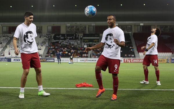 Qatar's national team players wear t-shirts bearing portraits of Emir Sheikh Tamim bin Hamad Al-Thani, in support the Qatari leader in the ongoing diplomatic crisis surrounding Qatar and other Gulf countries as they warm up prior to their World Cup 2018 Asia qualifying football match between Qatar and South Korea at the Jassim Bin Hamad stadium in Doha on June 13, 2017. Qatar's national team players wear t-shirts bearing portraits of Emir Sheikh Tamim bin Hamad Al-Thani, in support the Qatari leader in the ongoing diplomatic crisis surrounding Qatar and other Gulf countries as they warm up prior to their World Cup 2018 Asia qualifying football match between Qatar and South Korea at the Jassim Bin Hamad stadium in Doha on June 13, 2017. - Sputnik International