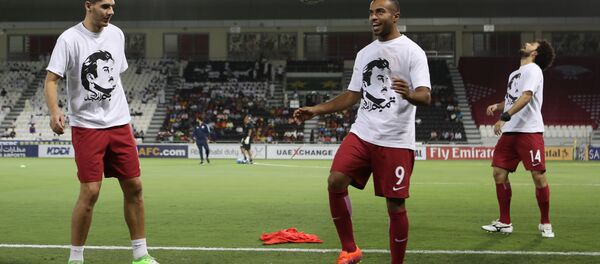 Qatar's national team players wear t-shirts bearing portraits of Emir Sheikh Tamim bin Hamad Al-Thani, in support the Qatari leader in the ongoing diplomatic crisis surrounding Qatar and other Gulf countries as they warm up prior to their World Cup 2018 Asia qualifying football match between Qatar and South Korea at the Jassim Bin Hamad stadium in Doha on June 13, 2017. Qatar's national team players wear t-shirts bearing portraits of Emir Sheikh Tamim bin Hamad Al-Thani, in support the Qatari leader in the ongoing diplomatic crisis surrounding Qatar and other Gulf countries as they warm up prior to their World Cup 2018 Asia qualifying football match between Qatar and South Korea at the Jassim Bin Hamad stadium in Doha on June 13, 2017. - Sputnik International