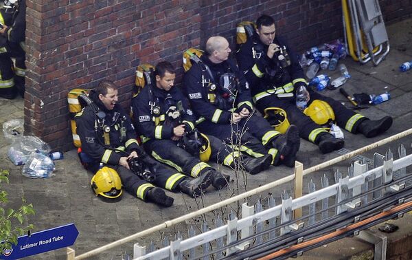 Firefighters rest as they take a break in battling a massive fire that raged in a high-rise apartment building in London, Wednesday, June 14, 2017. Firefighters rest as they take a break in battling a massive fire that raged in a high-rise apartment building in London, Wednesday, June 14, 2017. - Sputnik International