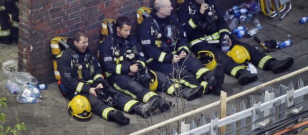 Firefighters rest as they take a break in battling a massive fire that raged in a high-rise apartment building in London, Wednesday, June 14, 2017. Firefighters rest as they take a break in battling a massive fire that raged in a high-rise apartment building in London, Wednesday, June 14, 2017. - Sputnik International