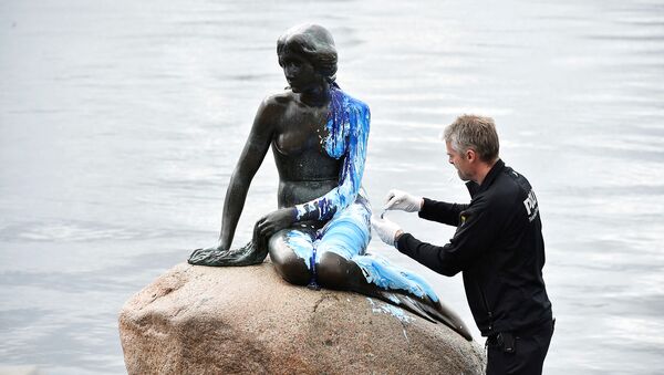 A police officer inspects the Little Mermaid statue, seen covered in paint, for the second time in weeks, in what local authorities say is an act of vandalism, in Copenhagen, Denmark June 14, 2017 - Sputnik International