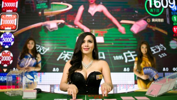 A baccarat dealer looks on during a demonstration at the Global Gaming Expo Asia held in Macau on May 17, 2016. - Sputnik International