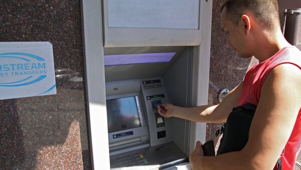 A city resident at a cash dispenser operated by the Central Republican Bank in Donetsk - Sputnik International