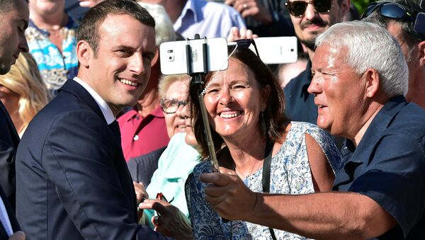 French President Emmanuel Macron (L) poses for a selfie after he voted in the second round parliamentary elections in Le Touquet, France, June 18, 2017 - Sputnik International
