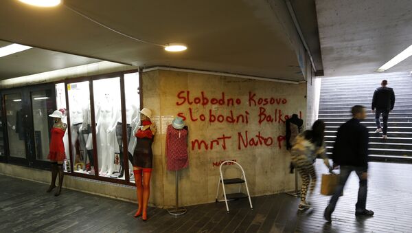 People pass through an underground passage with graffiti on the wall that reads: Free Kosovo, Free Balkan, Death for NATO, in Belgrade, Serbia (File) - Sputnik International